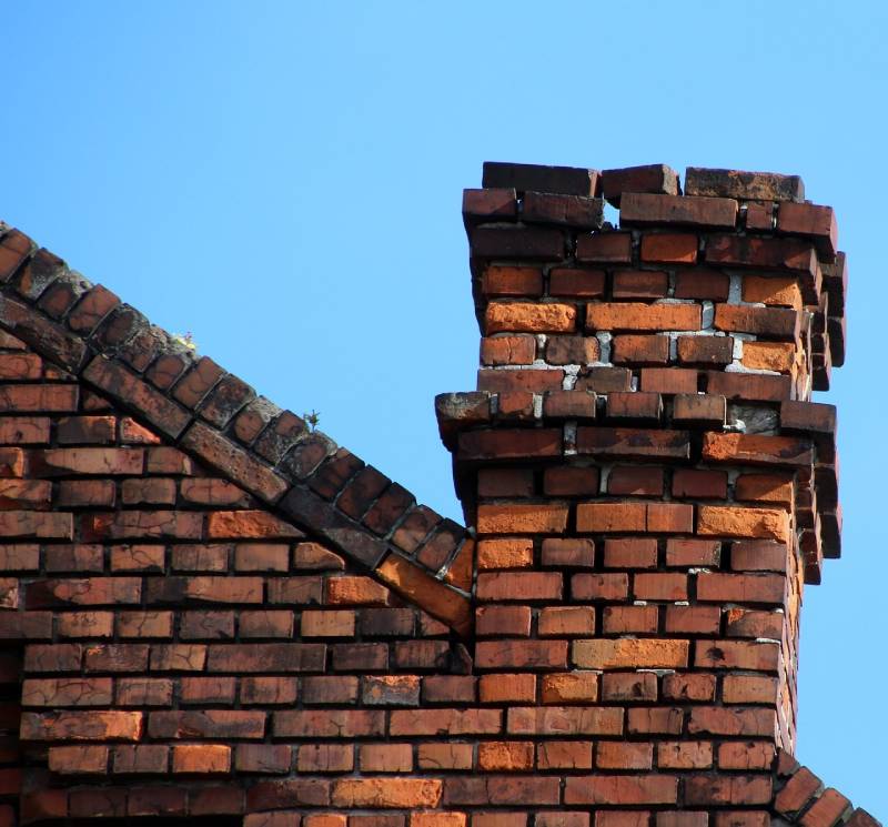 Damaged chimney on an Sunny Isles Beach home showing cracks and missing mortar
